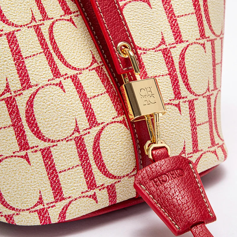 Close-up of a red and beige handbag with a gold clasp on a white background