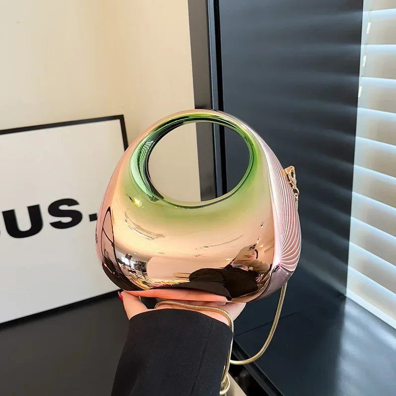 Gold and green spherical object held by a hand with a blurred background