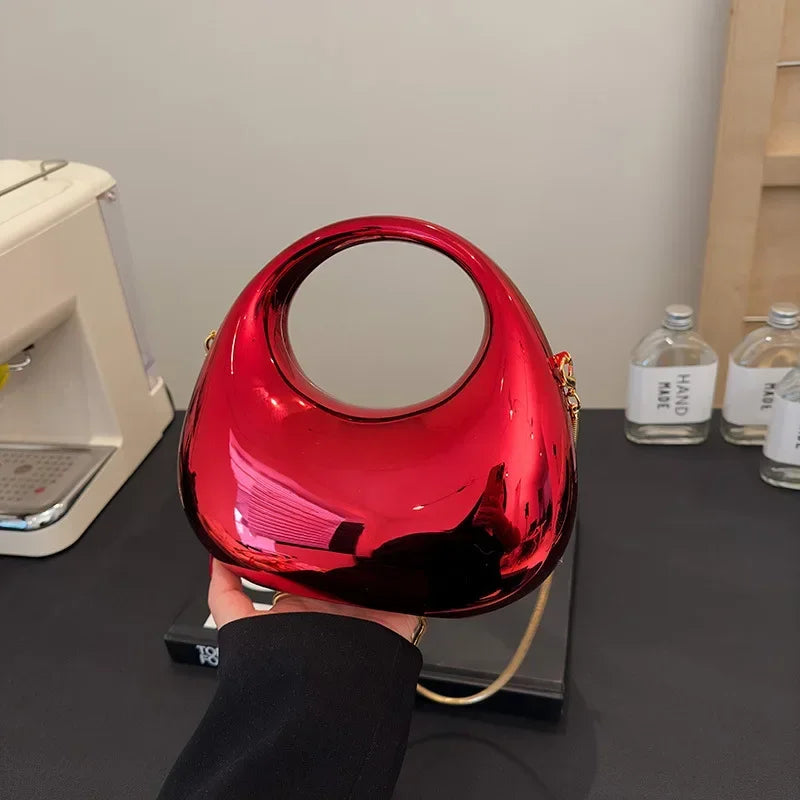 Red handbag held by a person with a neutral background