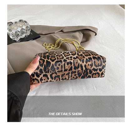 Carauana_UNIU_Leopard_Clutch held by a hand on a neutral background