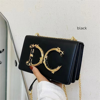 Dolce CaRaUaNa Clutch Bag with gold chain and 'DC' logo held by a hand