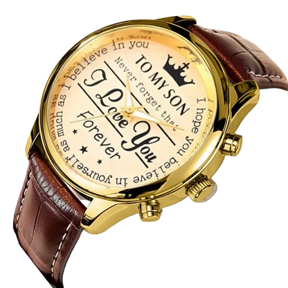 Gold watch with brown leather strap featuring engraved text on a light gray background
