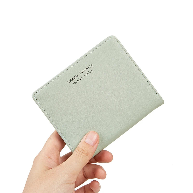 Light green wallet held by a hand